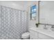 Bathroom features a shower with a patterned curtain, toilet, and white vanity sink at 9906 E Wavelength Ave, Mesa, AZ 85212