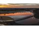 Picturesque community pond reflecting a vibrant sunset, complete with walking trails and lush landscaping at 9906 E Wavelength Ave, Mesa, AZ 85212