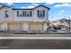 Exterior view of townhome featuring a two-car garage, stone accents, and a well-maintained front yard at 9906 E Wavelength Ave, Mesa, AZ 85212