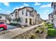 A long view along the side of a two-story townhome with beautiful desert-like landscaping and a sidewalk at 9906 E Wavelength Ave, Mesa, AZ 85212