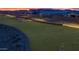 Expansive green space with a walking path lined by a retaining wall, perfect for evening strolls and relaxation at 9906 E Wavelength Ave, Mesa, AZ 85212