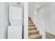 Functional laundry area with a stacked washer and dryer, and stairs to upper level at 9906 E Wavelength Ave, Mesa, AZ 85212
