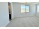 Bright bedroom with carpet flooring and a window with views, plus a glimpse into an adjacent bathroom at 15146 W Gray Fox Trl, Surprise, AZ 85387