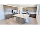 Modern kitchen boasts a central island, stainless steel appliances, and light countertops with grey backsplash at 15146 W Gray Fox Trl, Surprise, AZ 85387
