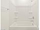 Clean white bathtub with shower and built-in shelving at 16015 W Desert Hollow Dr, Surprise, AZ 85387