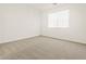 Bright bedroom features neutral carpet, a window, and fresh white paint at 16015 W Desert Hollow Dr, Surprise, AZ 85387