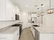 Stylish kitchen with white cabinets, granite countertops, stainless steel appliances, and pendant lighting at 16015 W Desert Hollow Dr, Surprise, AZ 85387