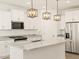 Modern kitchen with white cabinets, stainless steel appliances, granite countertops, and stylish lighting at 16015 W Desert Hollow Dr, Surprise, AZ 85387