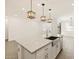 Spacious kitchen island with stainless sink, white cabinets, and modern pendant lighting at 16015 W Desert Hollow Dr, Surprise, AZ 85387