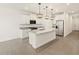 Bright kitchen featuring white cabinets, stainless steel appliances, a spacious island, and pendant lighting at 16015 W Desert Hollow Dr, Surprise, AZ 85387