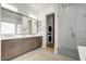 Contemporary bathroom with double vanity, glass shower, and adjacent laundry area, designed for convenience at 100 W Northern Ave # 6, Phoenix, AZ 85021