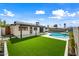 Beautiful backyard featuring lush artificial grass, a sparkling pool, and a covered patio at 1012 E Magdalena Dr, Tempe, AZ 85283