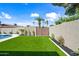 Private backyard featuring a well-maintained artificial lawn, mature trees, and tasteful landscaping at 1012 E Magdalena Dr, Tempe, AZ 85283