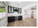 Stylish bar area featuring dark cabinetry, a wine fridge, elegant backsplash, and an adjacent open living space at 1012 E Magdalena Dr, Tempe, AZ 85283