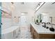 Bright bathroom features double sinks, wood cabinets, free standing tub, and tile floors at 1012 E Magdalena Dr, Tempe, AZ 85283