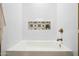 A soaking tub with a decorative tiled niche, showcasing a blend of style and functionality at 1012 E Magdalena Dr, Tempe, AZ 85283
