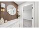 Hallway with a round mirror, wooden wall detail, and an entry to a carpeted room at 1012 E Magdalena Dr, Tempe, AZ 85283