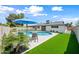 Stunning backyard with lush turf, a pristine pool, and a charming covered patio and lounge area at 1012 E Magdalena Dr, Tempe, AZ 85283