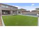 A serene backyard features an outdoor living space, artificial turf and a pool with lounge chairs at 10792 W Whitehorn Way, Peoria, AZ 85383