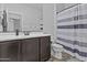 Stylish bathroom featuring a vanity, toilet, mirror, and a shower with a blue striped curtain at 10792 W Whitehorn Way, Peoria, AZ 85383