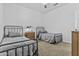 Cozy bedroom featuring two iron framed beds with plush grey bedding and a wooden nightstand at 10792 W Whitehorn Way, Peoria, AZ 85383