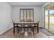 Bright dining room boasts wood floors, a modern table and seating, and sliding glass doors to a patio at 10792 W Whitehorn Way, Peoria, AZ 85383