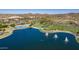A scenic aerial captures a community lake, a park with tall palms, and hillside views at 10866 S Dreamy Dr, Goodyear, AZ 85338