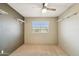 Bedroom features a ceiling fan, a window, shelving, neutral walls, and plush carpeting at 10866 S Dreamy Dr, Goodyear, AZ 85338