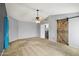 Bedroom featuring carpeted floors and a sliding barn door accent at 10866 S Dreamy Dr, Goodyear, AZ 85338