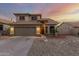 Exterior view of a two-story home with a tile roof, a two-car garage, and desert landscaping at 10866 S Dreamy Dr, Goodyear, AZ 85338