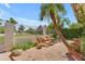 Backyard patio featuring a rock water feature, a leaning palm tree, and privacy fence at 11465 N 56Th St, Scottsdale, AZ 85254