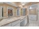 Bathroom boasts double sinks, granite countertops, white cabinetry, and walk-in closet access at 11465 N 56Th St, Scottsdale, AZ 85254