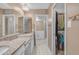 Bathroom boasts double sinks, granite countertops, white cabinetry, and walk-in closet access at 11465 N 56Th St, Scottsdale, AZ 85254