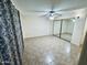 Bedroom features tile flooring, ceiling fan, and standard closet with mirrored doors at 12221 S Paiute St, Phoenix, AZ 85044