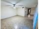 Light-filled living room with tile flooring, ceiling fan, and connections to kitchen and hallway at 12221 S Paiute St, Phoenix, AZ 85044