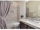 Bright bathroom featuring marble tile, a shower/tub, and a vanity with light stone countertops at 12353 W Running Deer Trl, Peoria, AZ 85383