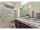 Luxurious bathroom with dual sinks, a marble countertop, modern tile floors, and a glass-enclosed shower at 12353 W Running Deer Trl, Peoria, AZ 85383