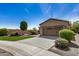 Beautiful home displaying lush landscaping, decorative rocks, and a large driveway leading to a two-car garage at 12353 W Running Deer Trl, Peoria, AZ 85383