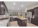 Open kitchen featuring stainless steel appliances, a kitchen island, and dark wood cabinetry at 12353 W Running Deer Trl, Peoria, AZ 85383