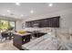Modern kitchen featuring an island with marble countertops, stainless steel appliances, and sleek dark cabinets at 12353 W Running Deer Trl, Peoria, AZ 85383