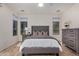Bright bedroom with wood floors, neutral decor, and a large upholstered headboard with decorative pillows at 12353 W Running Deer Trl, Peoria, AZ 85383