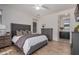 Comfortable main bedroom features wood floors, gray upholstered bed frame, and views to a wet bar and en suite at 12353 W Running Deer Trl, Peoria, AZ 85383