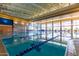 Bright indoor pool with swimming lanes and large windows allowing for plenty of natural light and beautiful reflections at 12353 W Running Deer Trl, Peoria, AZ 85383