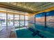 Bright indoor pool with swimming lanes and large windows allowing for plenty of natural light and beautiful reflections at 12353 W Running Deer Trl, Peoria, AZ 85383