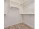 Empty walk-in closet with hardwood floors and white shelving and closet rods for optimal storage at 12353 W Running Deer Trl, Peoria, AZ 85383
