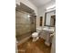 Bathroom features a glass-enclosed shower, travertine tile, and a pedestal sink at 15243 N 52Nd Dr, Glendale, AZ 85306