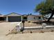 Charming single-story home with a gray garage door, xeriscaping and a well-maintained yard at 15243 N 52Nd Dr, Glendale, AZ 85306
