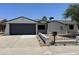 Charming single-story home with a gray garage door, xeriscaping and a well-maintained yard at 15243 N 52Nd Dr, Glendale, AZ 85306