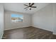 The bedroom features a modern ceiling fan, neutral walls, a window with blinds, and wood-look flooring at 15346 W Hearn Rd, Surprise, AZ 85379