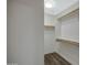 Walk-in closet has built-in wooden shelves and rods for easy storage at 15346 W Hearn Rd, Surprise, AZ 85379